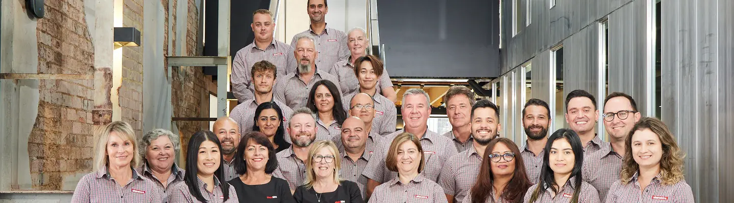 Employees gathered at a workplace event, smiling and celebrating 16 years of company success and teamwork.