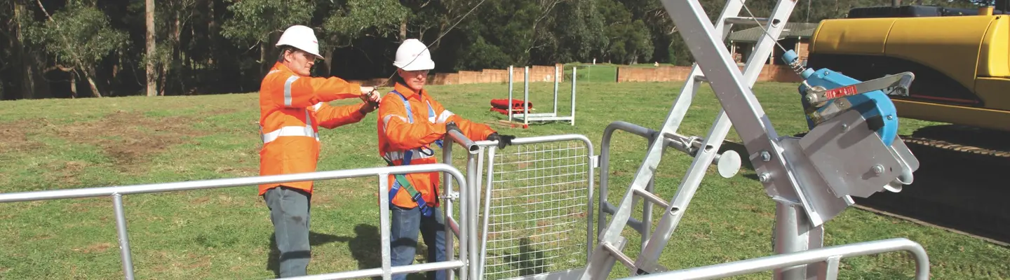 Workers installing edge protection equipment on a construction site to prevent falls and enhance site safety