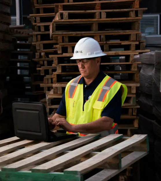 man in hardhat on computer
