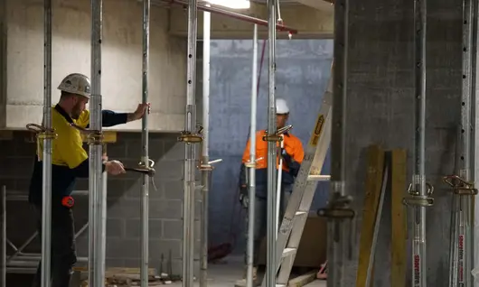 Workers installing temporary support props at a construction site to ensure structural safety and stability.