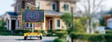 An electronic message board sign on the roadside displaying safety or construction information near a work zone with barriers.