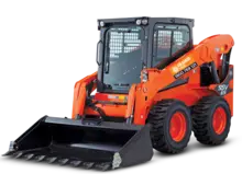 ruck loader at a construction site near safety barriers and portable equipment, illustrating site logistics and heavy equipment use.