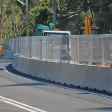 Safety barriers barricading a road construction zone to protect workers and guide vehicle traffic safely around the site.