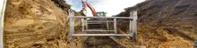 Workers installing structural braces in an underground excavation site to support trench walls and ensure safety during construction.