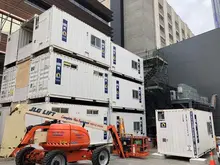  Large stack of storage containers arranged at an industrial site, representing logistics, storage, or construction use.